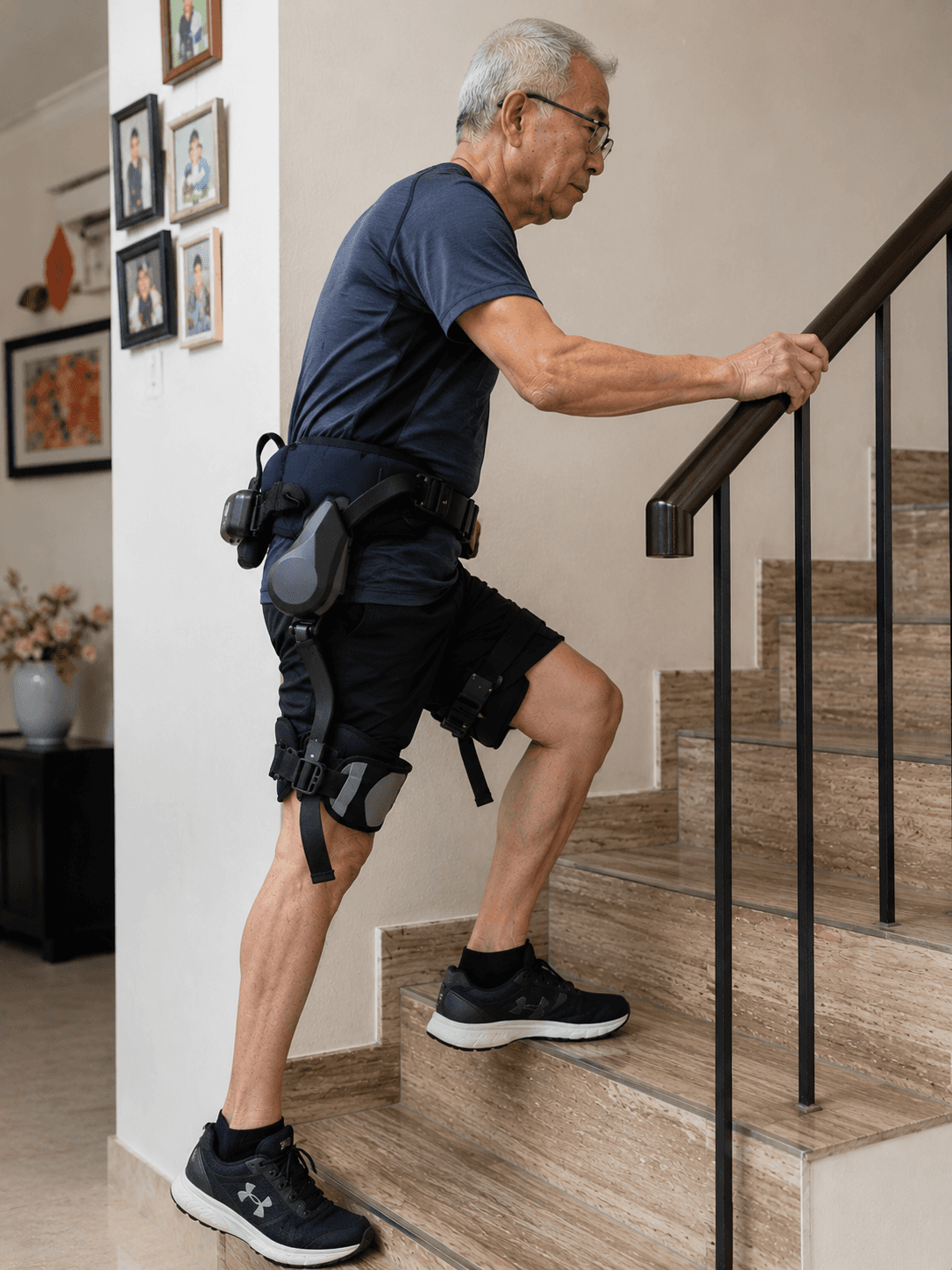 Elderly man climbing stairs at home with the walking exoskeleton for support